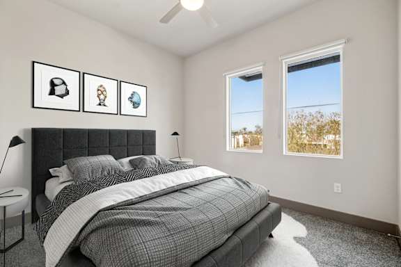 A bedroom with a bed, a nightstand, and a window.