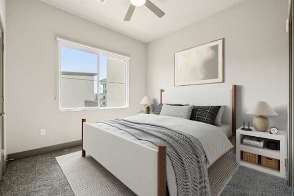 A bedroom with a large bed and a window overlooking a cityscape.