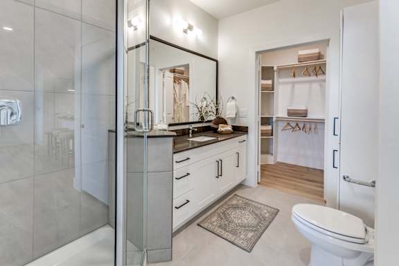 A bathroom with a toilet, sink, and mirror.