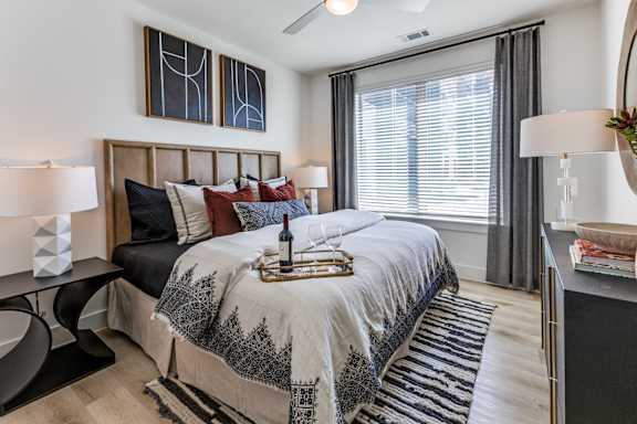 A bedroom with a large bed and a painting on the wall.