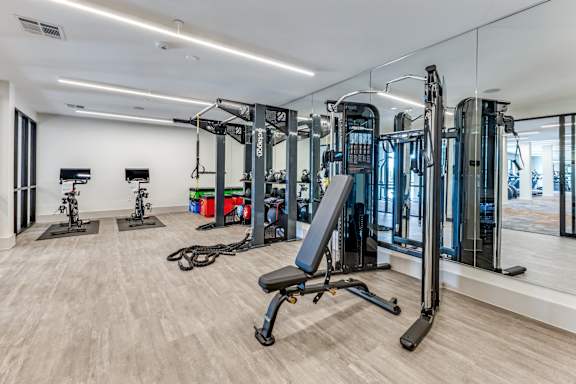 A gym with a variety of equipment including treadmills, weights, and exercise machines.