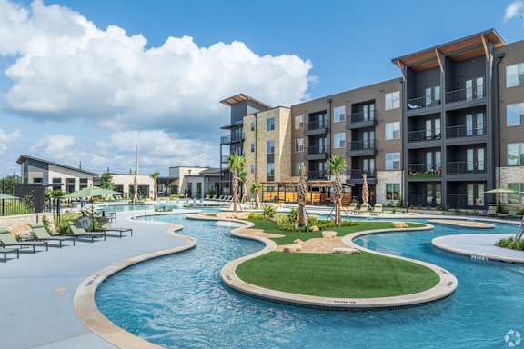 A large swimming pool in front of apartment buildings.