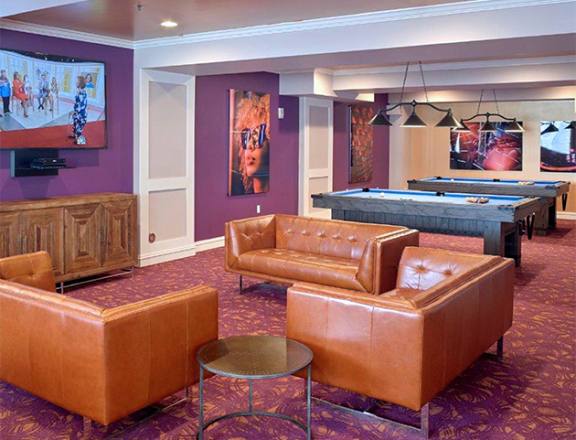 a recreation room with a pool table and couches