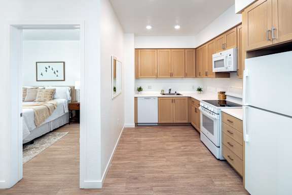 A kitchen with white appliances and wooden cabinets.