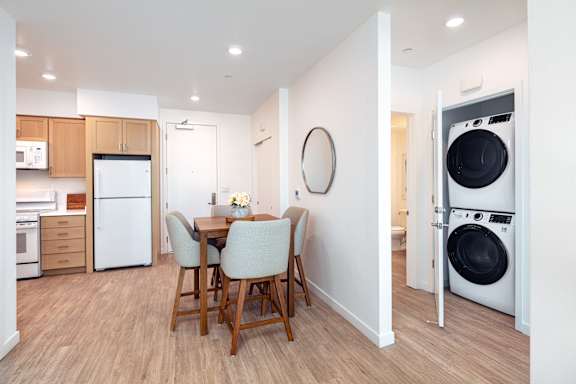 A modern kitchen with a dining table and chairs.