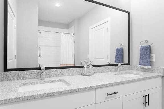 A bathroom with a large mirror above a double sink vanity.