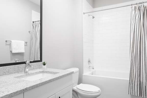 A white bathroom with a sink, toilet, and bathtub.