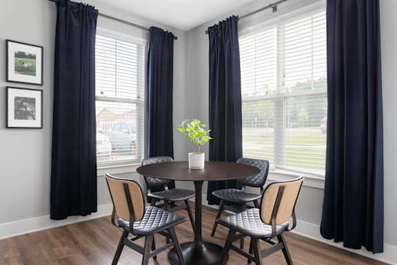 A dining room with a table and chairs.