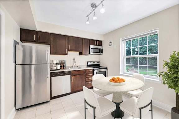 A kitchen with a table and chairs in front of a window.