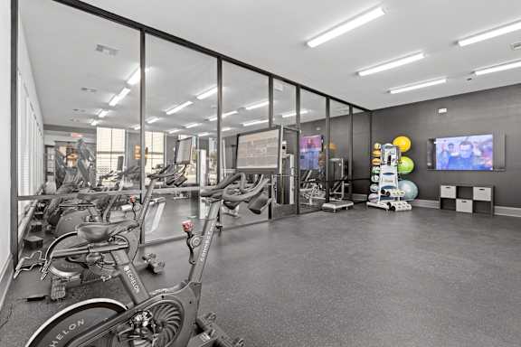 A gym with treadmills, exercise bikes, and other equipment.