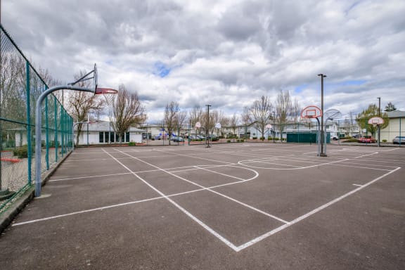 an empty basketball court in a park