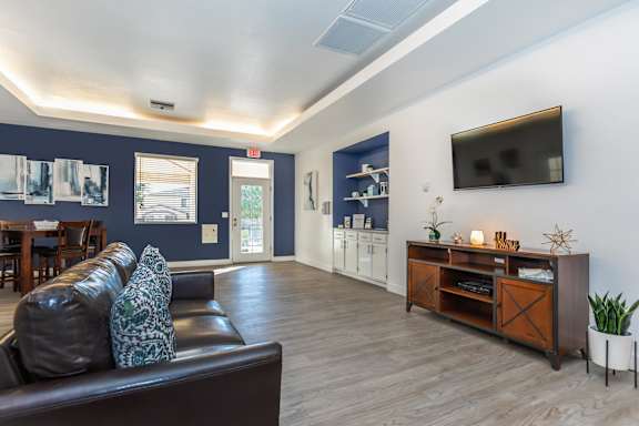 A living room with a brown leather couch and a wooden entertainment center.