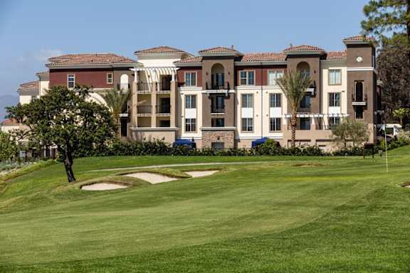 A large building with a green lawn in front of it.