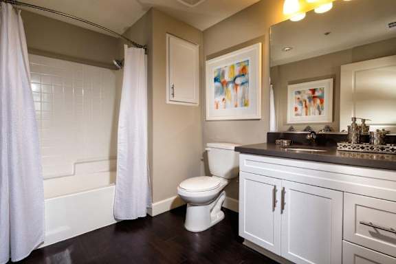 A bathroom with a toilet, sink, and shower.