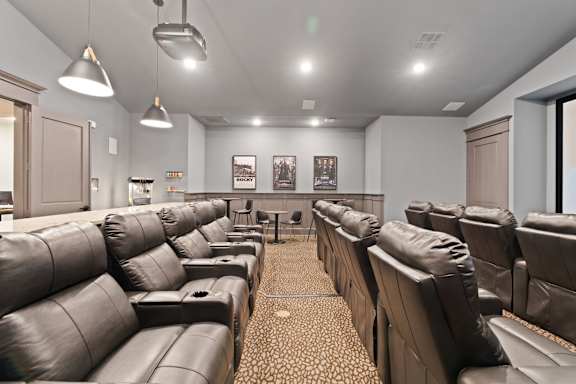 A row of brown leather seats in a movie theater.