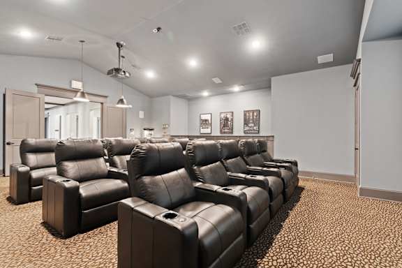 A row of black leather chairs are lined up in a room.