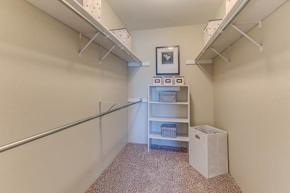 A small room with a shelf and a trash can.