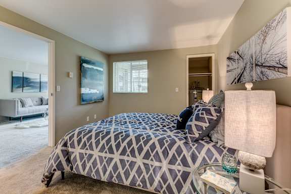 A bedroom with a large bed and a painting on the wall.