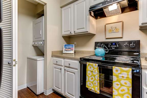 A kitchen with a stove top oven and a refrigerator.