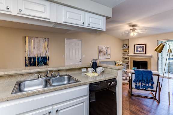 A kitchen with a sink, stove, and oven.