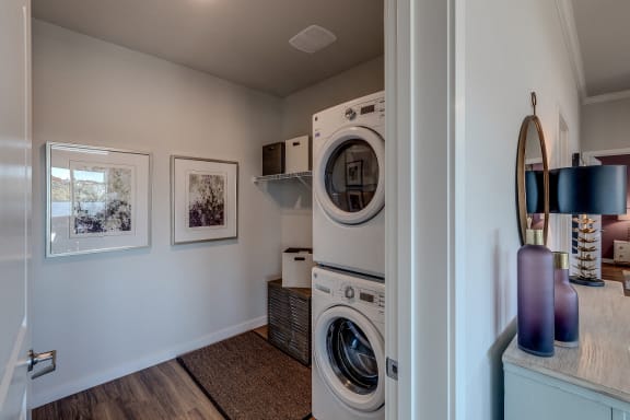 Lux Apartments Bellevue WA laundry room with front loading washer and dryer included and some added storage space