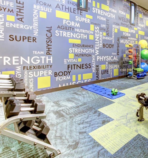 a gym with a mural of the word strength on the wall