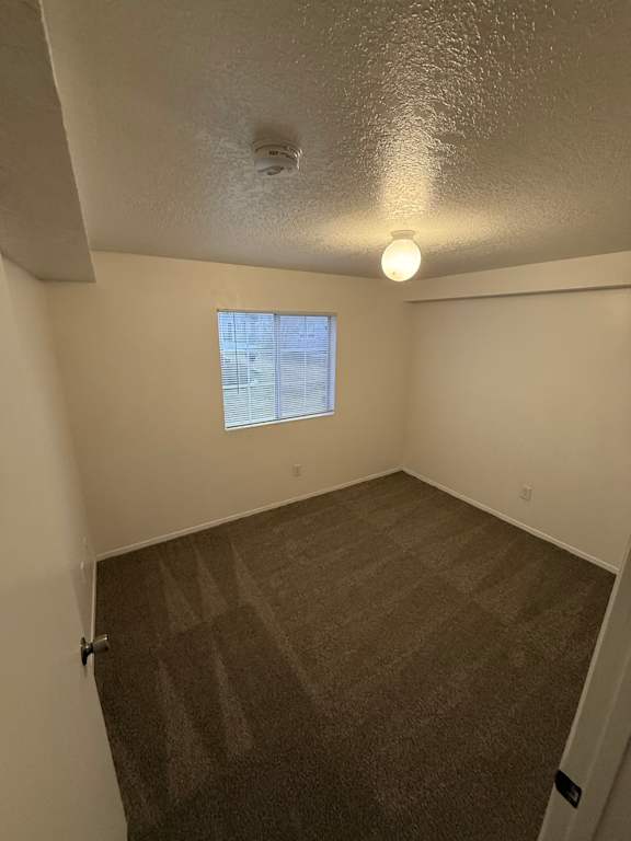 A small window in a room with a brown wallpaper.