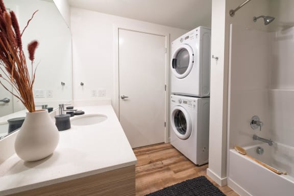 a kitchen with a washing machine and a sink and a washer and dryer at Wilcox, Seattle, 98107