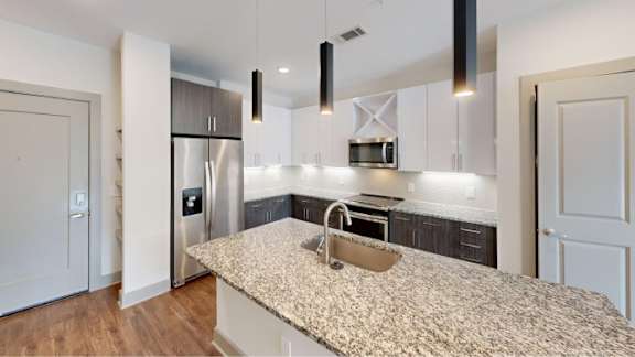 A kitchen with a granite countertop and a sink.
