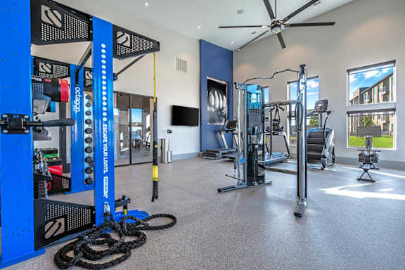 A gym with a variety of equipment including a weight rack, treadmill, and exercise bike.