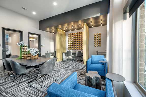 A modern dining room with a grey table and chairs.