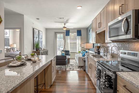 A modern kitchen with granite countertops and stainless steel appliances.