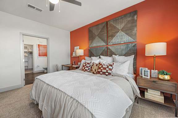A bedroom with a large bed and a ceiling fan.