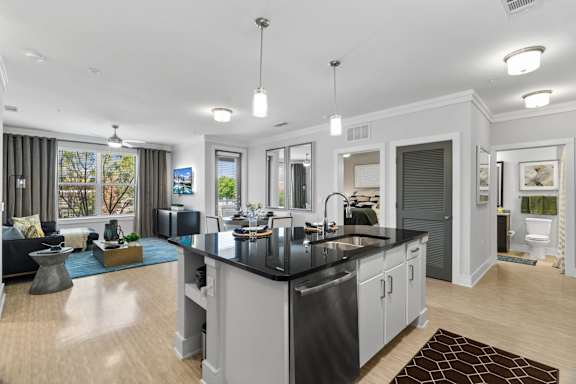 A modern kitchen with a black countertop and stainless steel appliances.