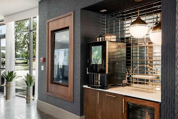 A modern kitchen with a wooden cabinet and a television on the counter.