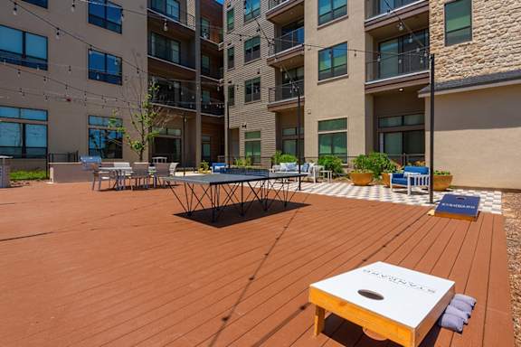 A wooden table is in the middle of a wooden deck.