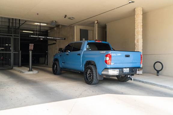 A blue pickup truck is parked in a garage.