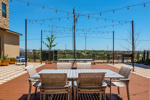 A patio with a table and chairs is set up for an outdoor gathering.