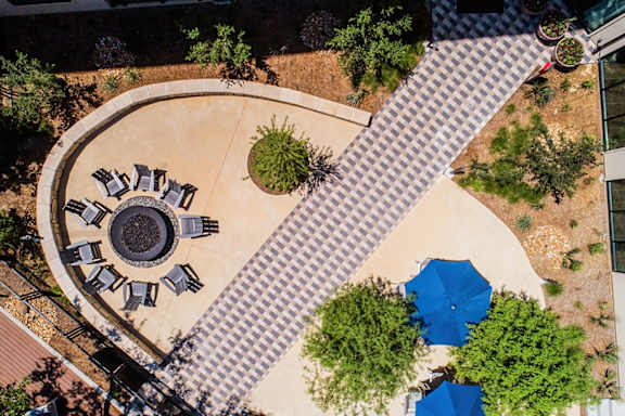 A circular patio with a fire pit and chairs.