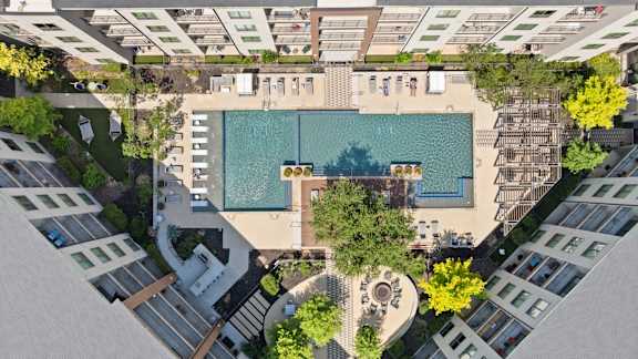 A swimming pool surrounded by buildings and trees.