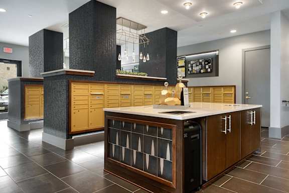 A kitchen with a black and white tiled backsplash and wooden cabinets.