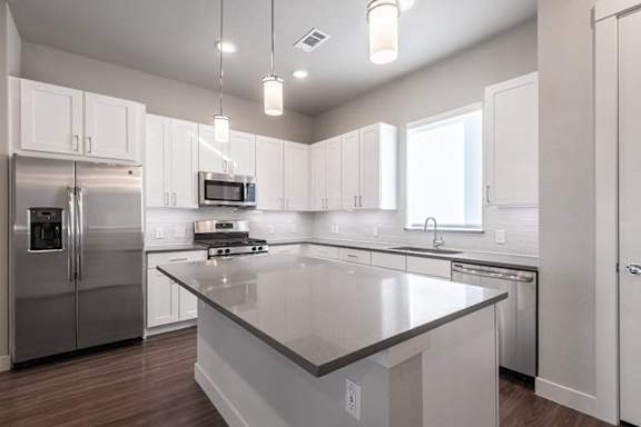 A modern kitchen with a large island in the center.