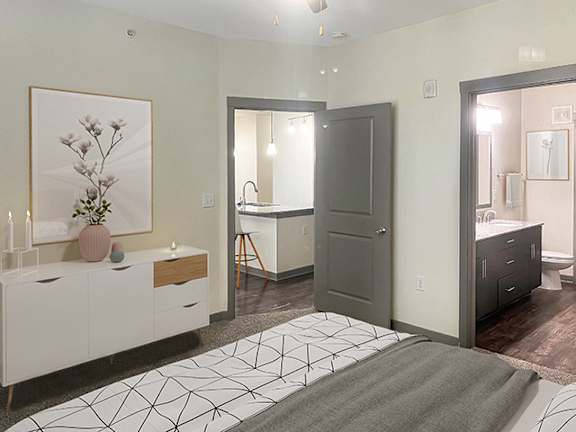 a bedroom with a bed and a bathroom with a sink and a mirror