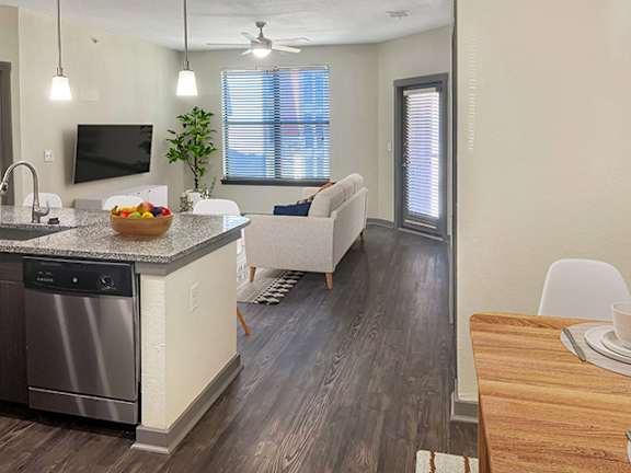 the view of a kitchen and living room from the dining room area of an apartment