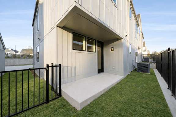 A modern house with a white exterior and a black fence.