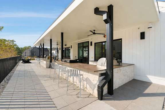 A modern building with a white exterior and a long row of white chairs.