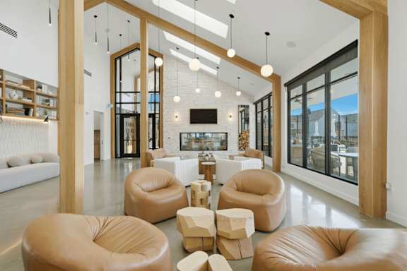 A modern living room with leather chairs and a television.