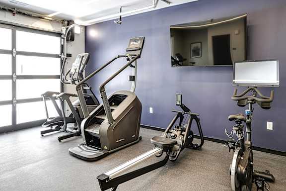 A gym with a mirror, treadmills, and exercise bikes.