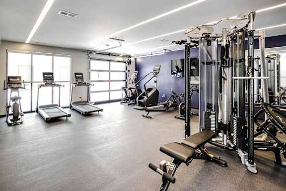 A spacious gym with a variety of equipment including treadmills, weights, and exercise machines.