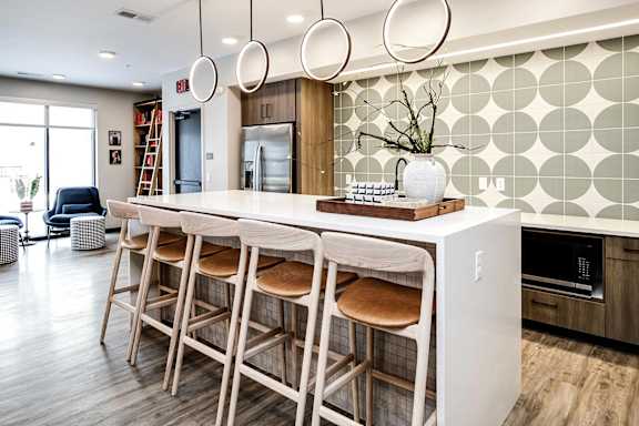 A kitchen with a bar area and a white countertop.